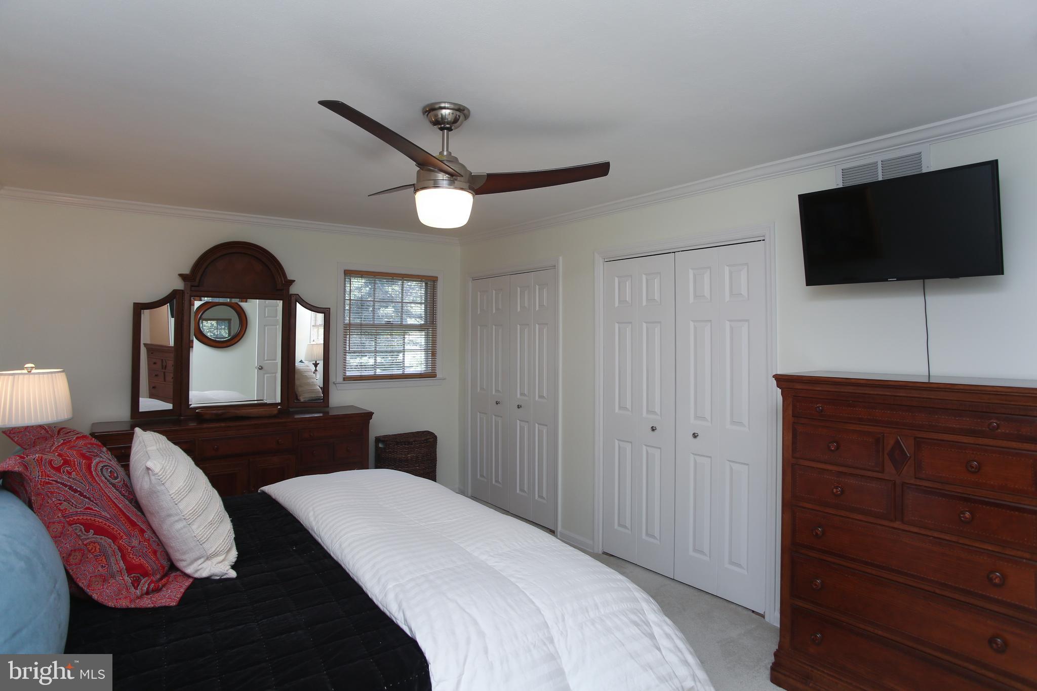 4 Indian Run Road Princeton Junction, NJ 08550 - Photo 27 of 43 a bedroom with a bed a mirror on dresser and a flat screen tv