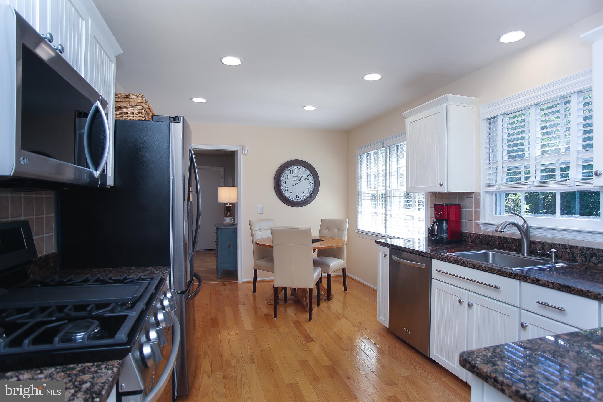 4 Indian Run Road Princeton Junction, NJ 08550 - Photo 10 of 43 a kitchen with stainless steel appliances granite countertop a stove a sink dishwasher a dining table and chair with wooden floor