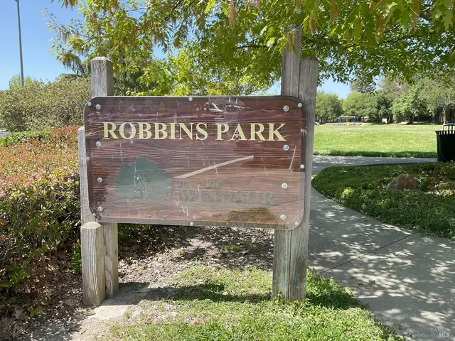 a view of a street sign under a large tree