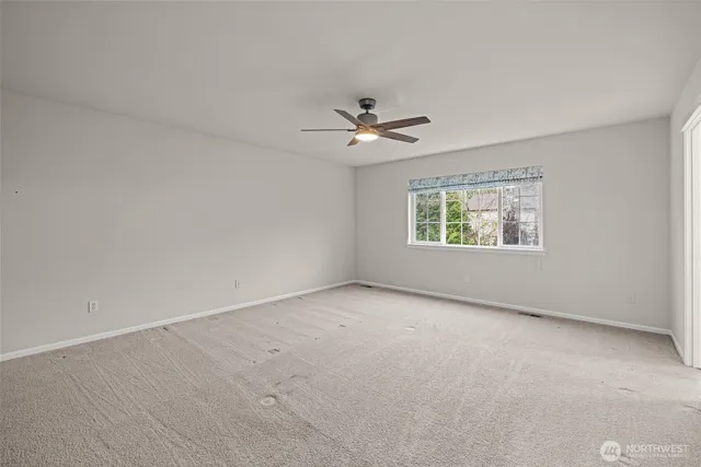 an empty room with a window and a ceiling fan