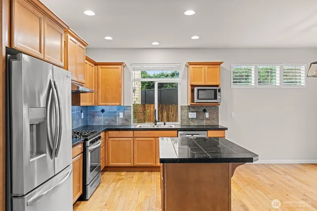 a kitchen with stainless steel appliances granite countertop a stove and a refrigerator