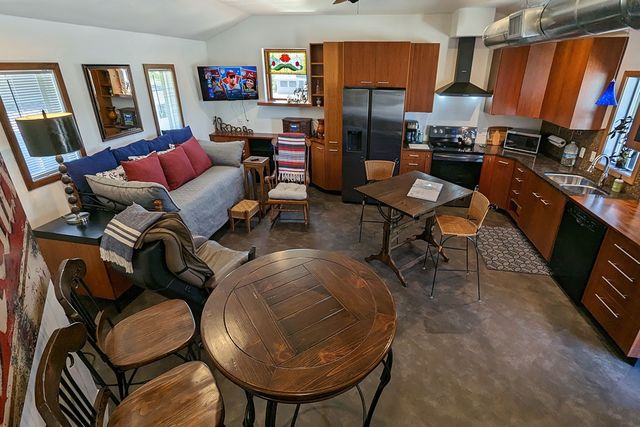 a bedroom with a bed a mirror on dresser and a window