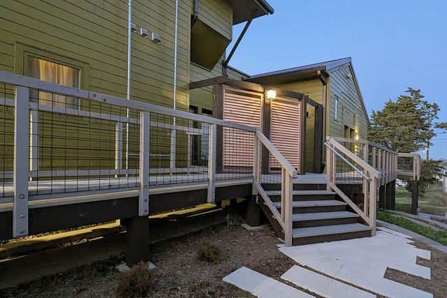 a kitchen with stainless steel appliances granite countertop a sink a stove and a living room
