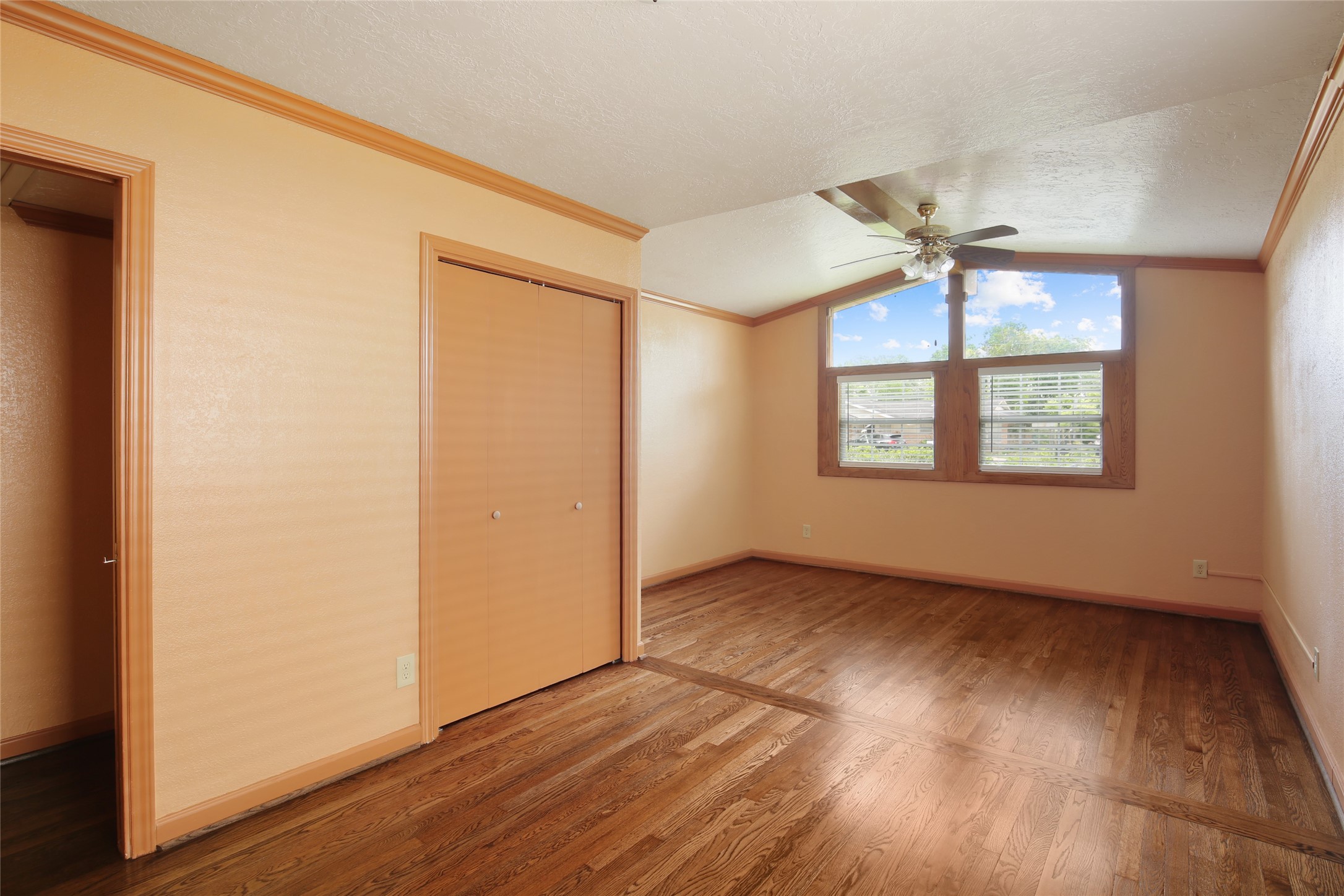 6923 Leader Street Houston, TX 77074 - Photo 4 of 19 an empty room with wooden floor chandelier fan and windows