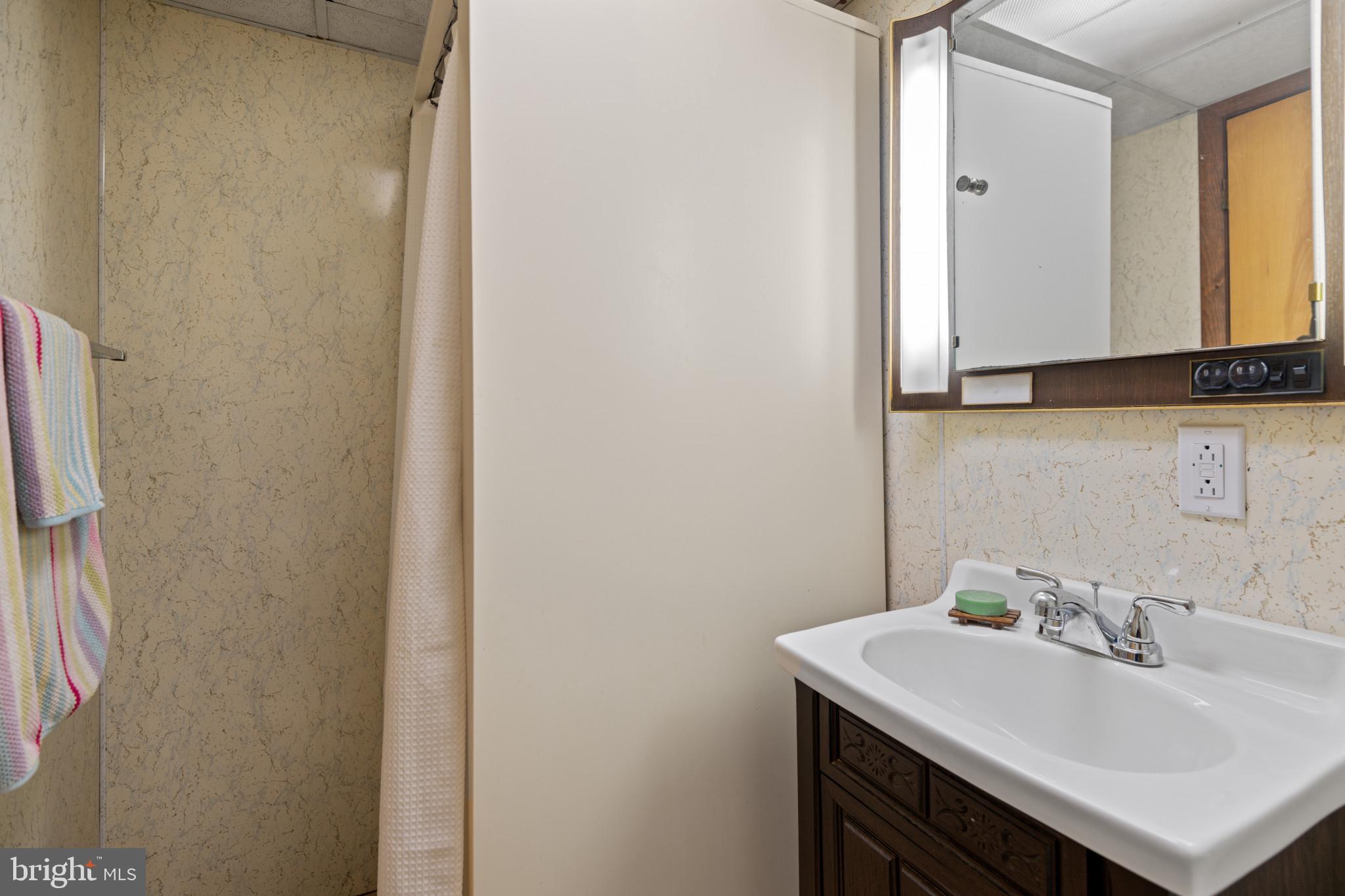 1228 West 37th Street Baltimore, MD 21211 - Photo 22 of 23 a bathroom with a sink and a mirror
