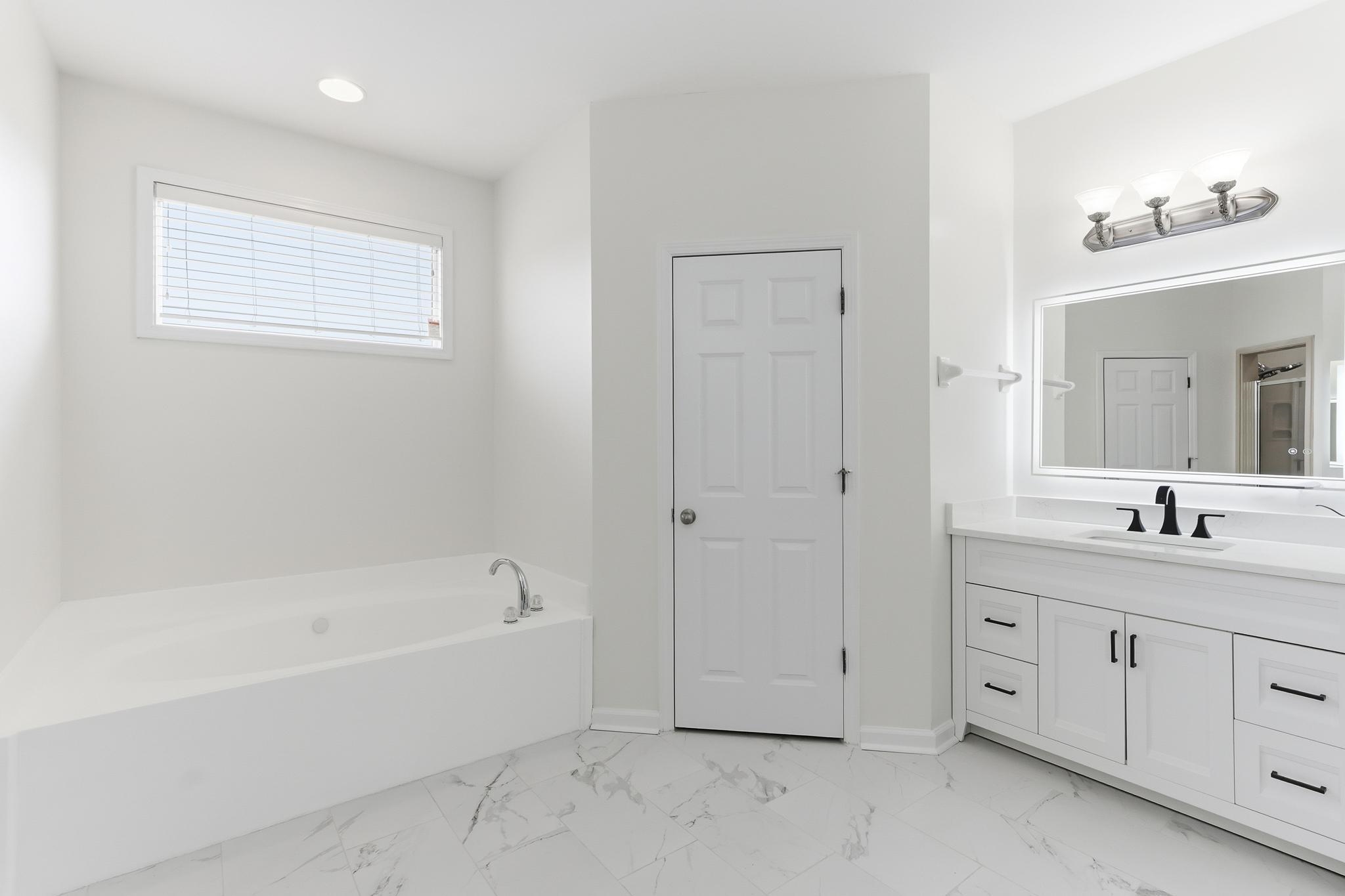 4854 Fox Springs Drive Collierville, TN 38017 - Photo 13 of 39 Bathroom with vanity, a garden tub, and light marble finish floors