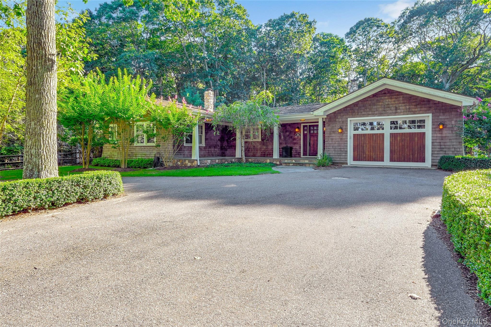 a front view of a house with a yard and trees