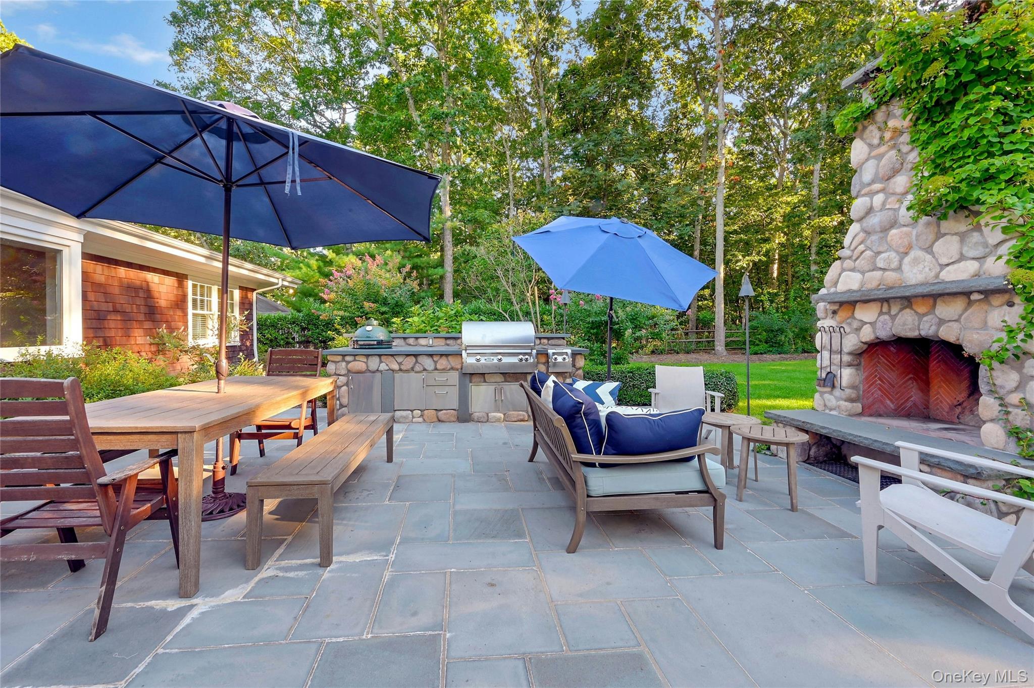 1600 Pine Tree Road Cutchogue, NY 11935 - Photo 18 of 27 a patio with tables and chairs under an umbrella