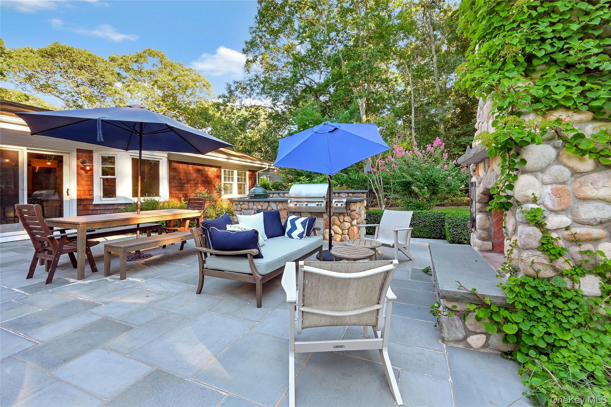 1600 Pine Tree Road Cutchogue, NY 11935 - Photo 20 of 27 a view of a patio with a dining table and chairs under an umbrella