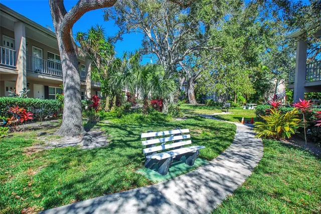 a garden with a bench in front of the house