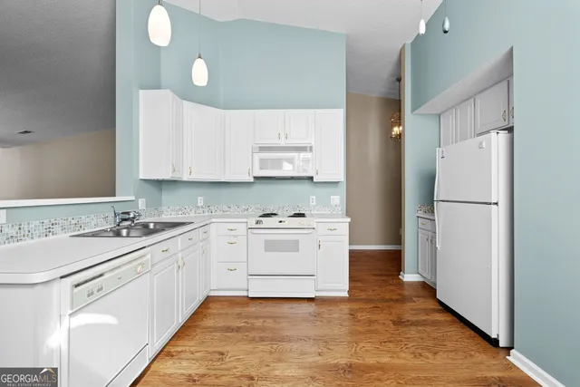 a kitchen with a sink cabinets stainless steel appliances and a window