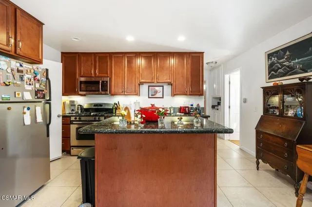 a kitchen with a refrigerator and a stove top oven