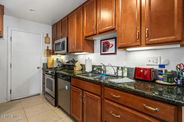 a kitchen with stainless steel appliances granite countertop a stove and cabinets