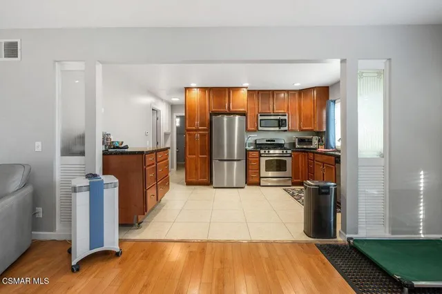 a kitchen with stainless steel appliances granite countertop a refrigerator a stove and a sink