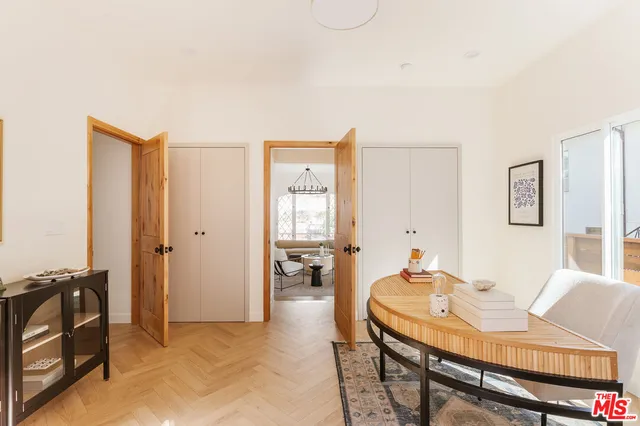 a living room with furniture a wooden floor and next to a window