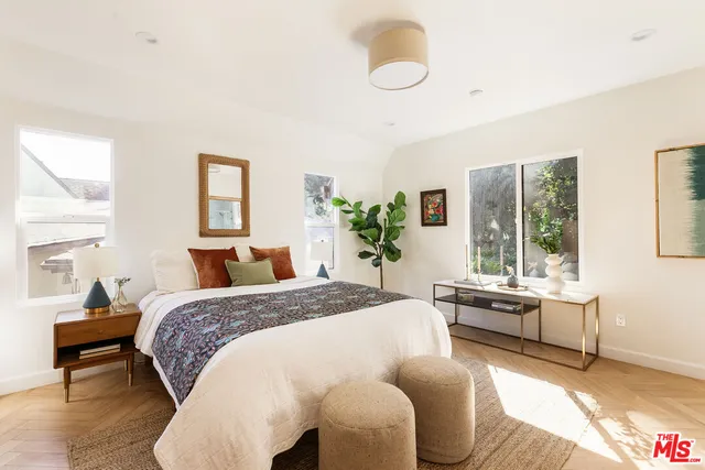 a bedroom with a bed and windows