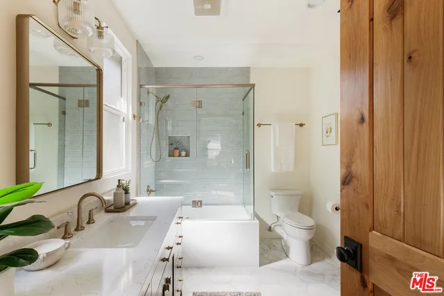 a bathroom with a bathtub shower sink and toilet