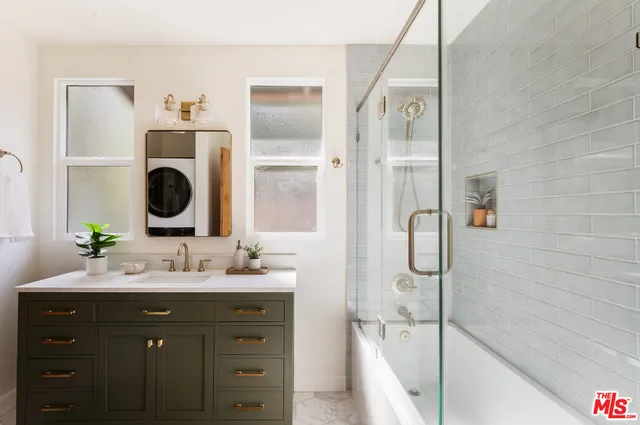 a bathroom with a bathtub sink and mirror