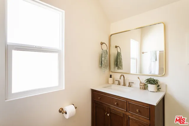 a bathroom with a sink vanity and mirror