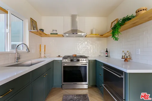a kitchen with stainless steel appliances a stove a sink and a microwave