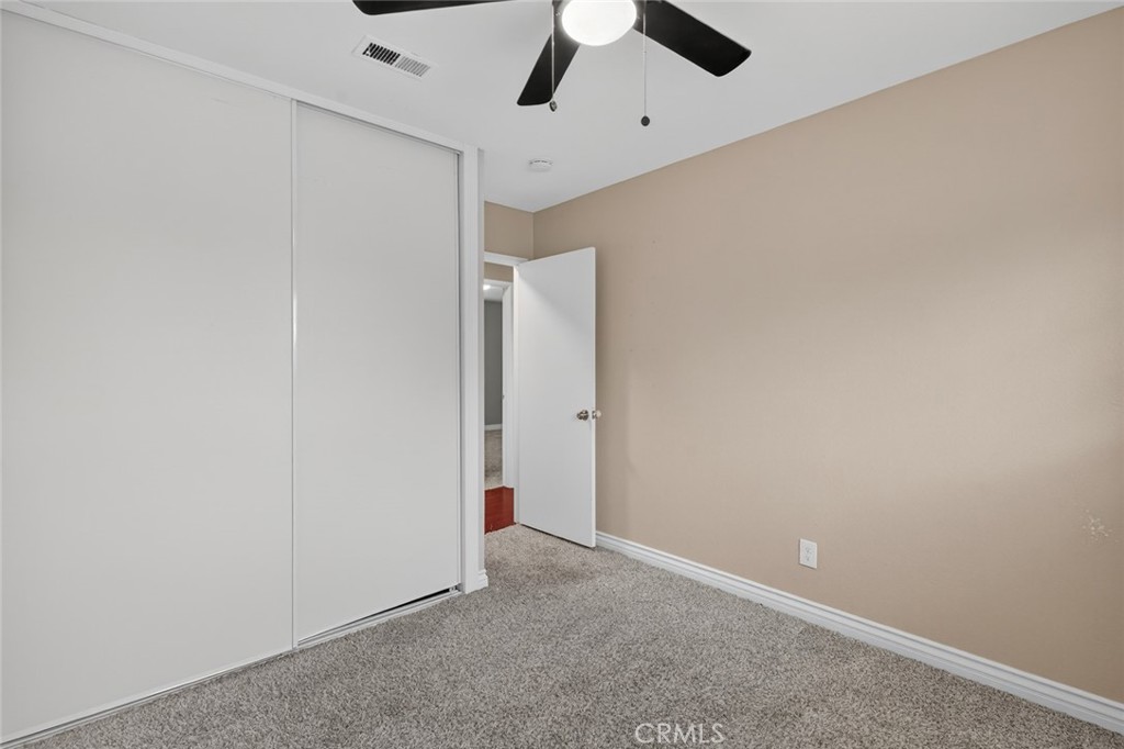 4060 Alto Street Oceanside, CA 92056 - Photo 30 of 56 an empty room with a ceiling fan and carpet