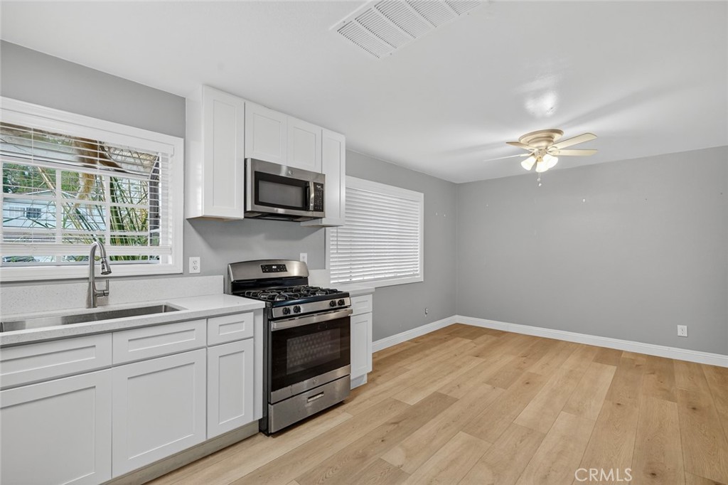 4060 Alto Street Oceanside, CA 92056 - Photo 4 of 56 a kitchen with a stove a sink and a microwave