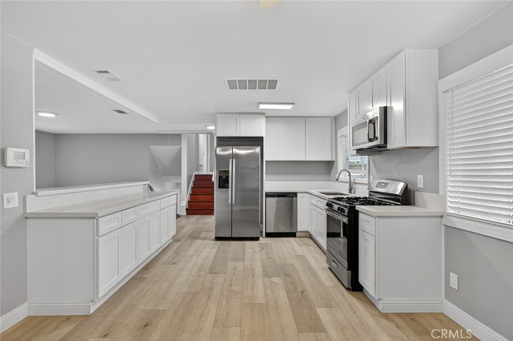4060 Alto Street Oceanside, CA 92056 - Photo 6 of 56 a large kitchen with stainless steel appliances a sink and cabinets