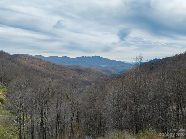 a view of a mountain in the distance in a cloudy sky