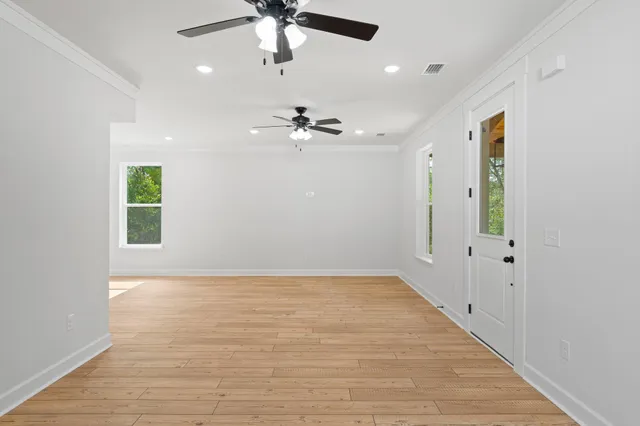 an empty room with fan and windows