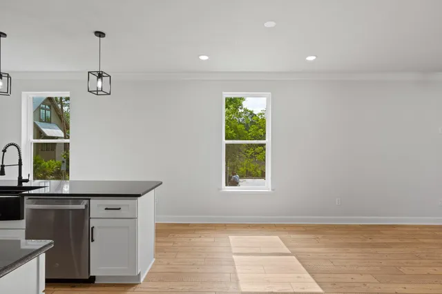 a view of kitchen with granite countertop cabinets and window