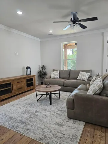 a living room with furniture and a wooden floor