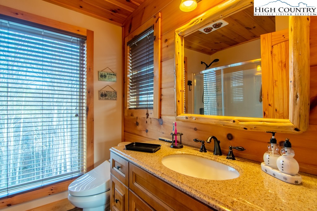 232 Bertie Circle Piney Creek, NC 28663 - Photo 19 of 50 a bathroom with a granite countertop sink and a mirror