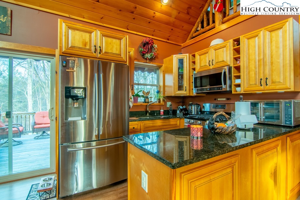 232 Bertie Circle Piney Creek, NC 28663 - Photo 27 of 50 a kitchen with stainless steel appliances granite countertop a refrigerator a stove and a wooden floor
