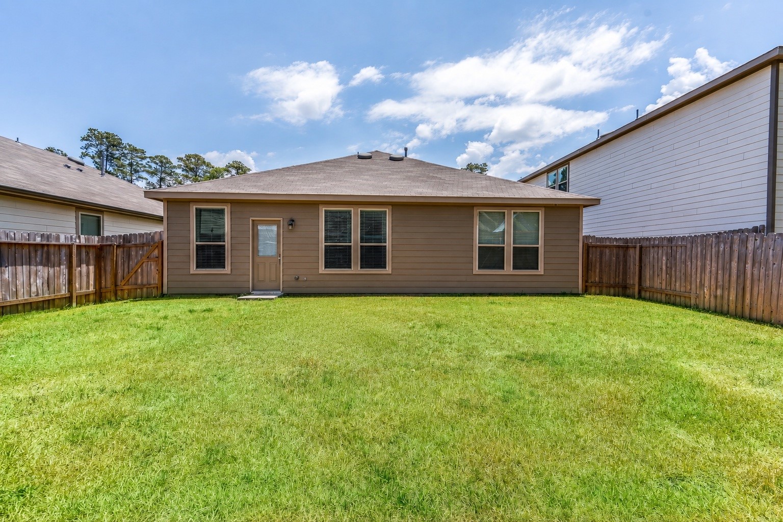 4256 Pine Still Road Conroe, TX 77304 - Photo 20 of 21 a view of a house with a backyard