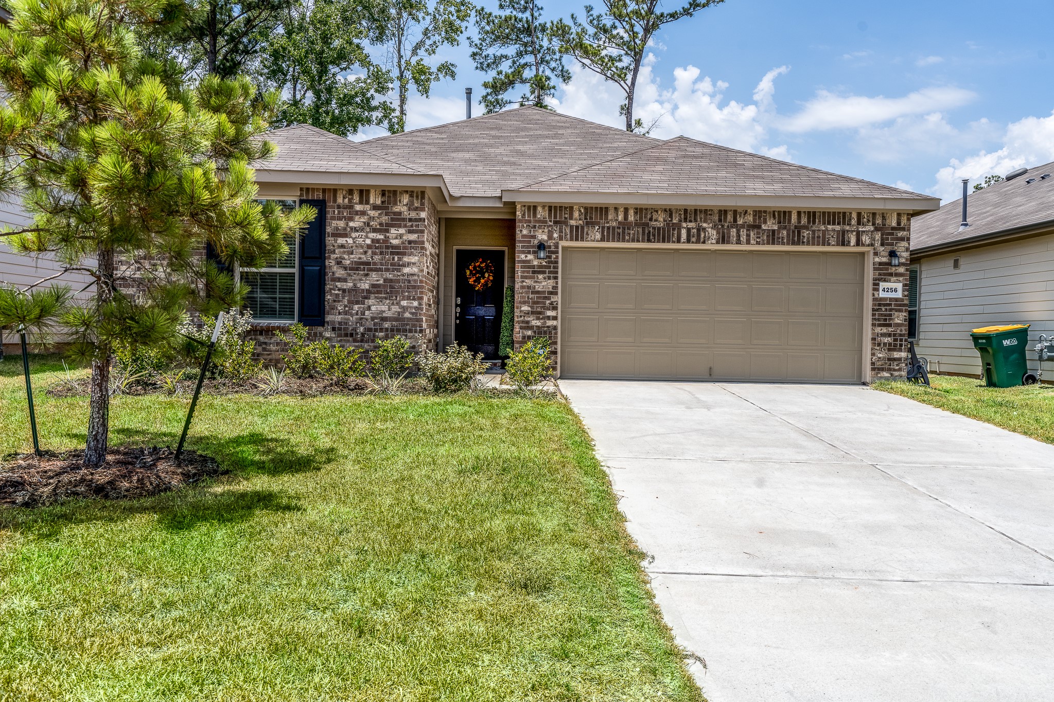 4256 Pine Still Road Conroe, TX 77304 - Photo 2 of 21 a front view of a house with a garden and yard