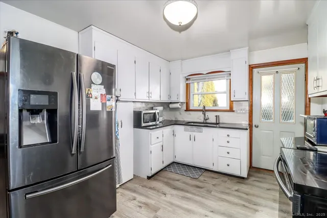 a kitchen with granite countertop a refrigerator stove and sink