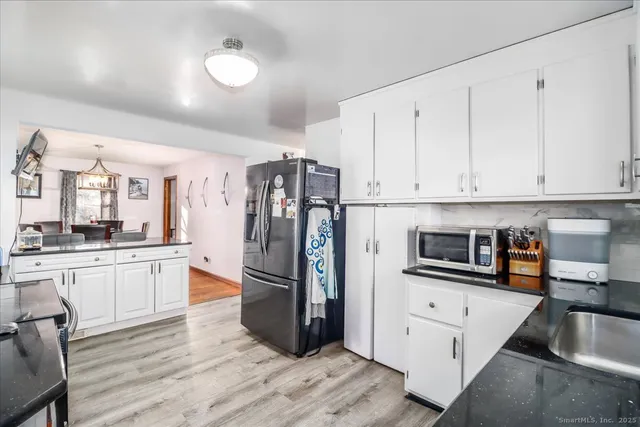 a kitchen with granite countertop a refrigerator and a sink