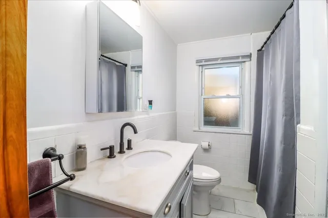 a bathroom with a sink a toilet and a mirror