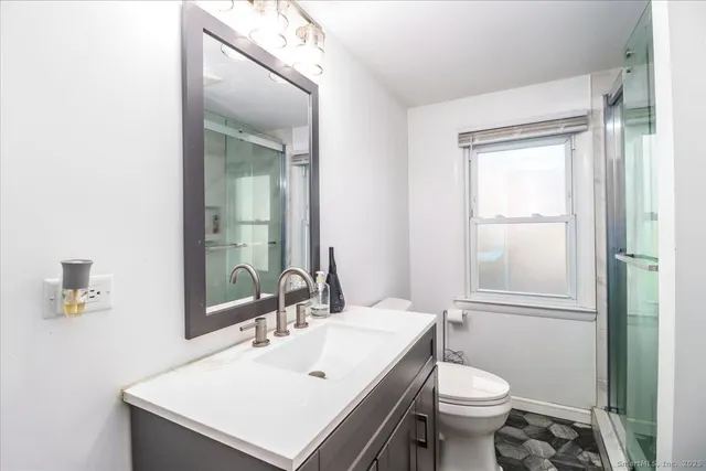 a bathroom with a sink a toilet and shower