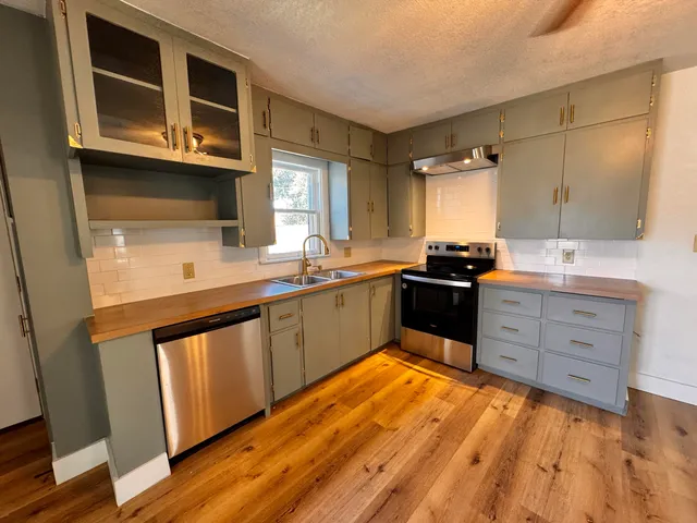 a kitchen with stainless steel appliances kitchen island granite countertop a sink and cabinets