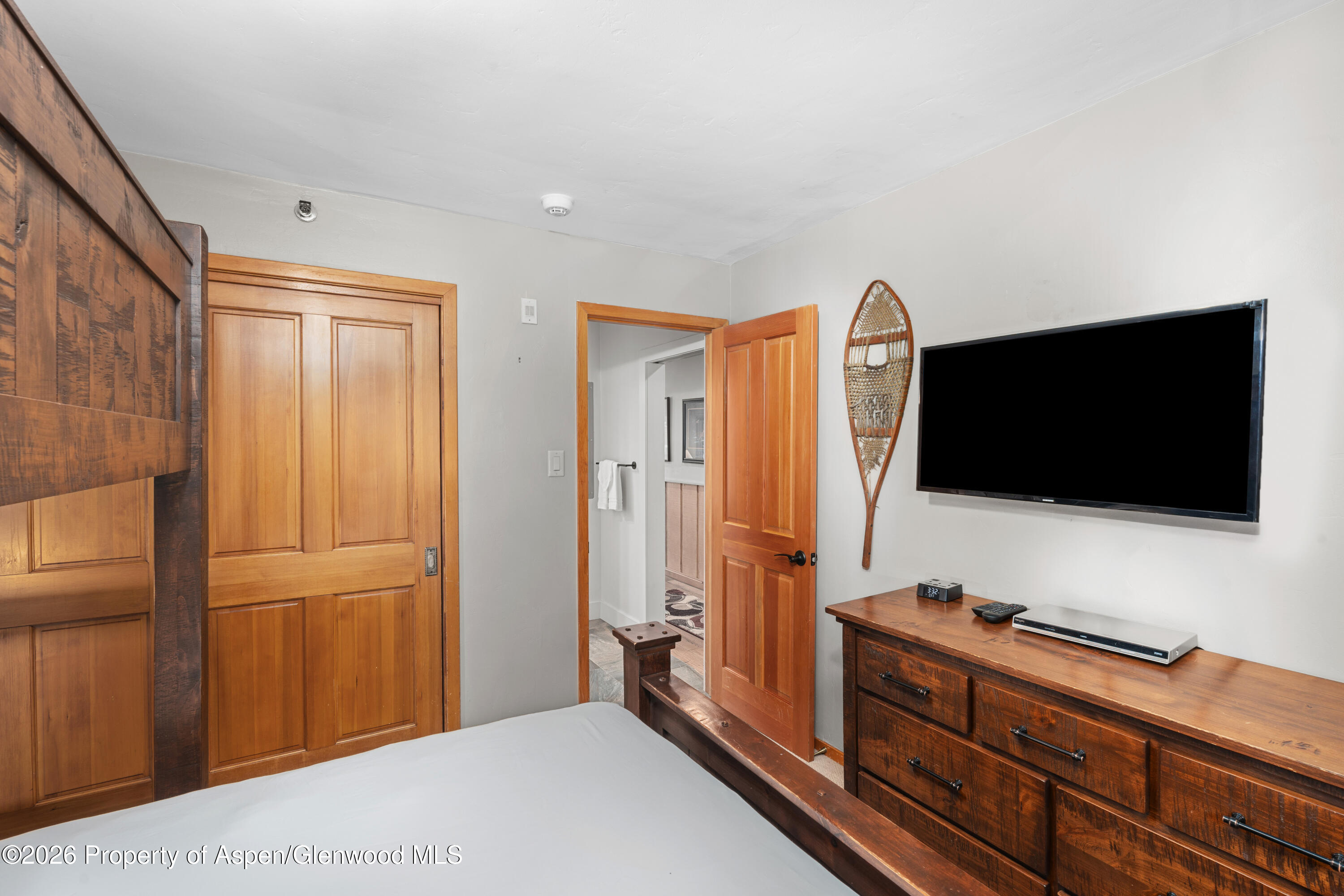 400 Wood Road, Unit 2111H Snowmass Village, CO 81615 - Photo 11 of 16 a living room with flat screen tv and a refrigerator