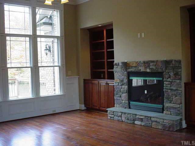3208 Cotten Road, Unit LOT89 Raleigh, NC 27603 - Photo 8 of 12 an empty room with wooden floor fireplace and windows