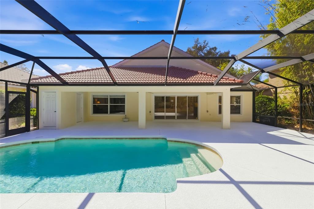 7631 Desert Inn Way Lakewood Ranch, FL 34202 - Photo 16 of 100 a patio with a table and chairs under an umbrella
