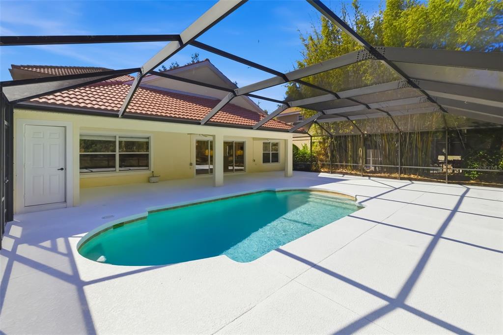 7631 Desert Inn Way Lakewood Ranch, FL 34202 - Photo 17 of 100 a view of a patio with a table and chairs under an umbrella