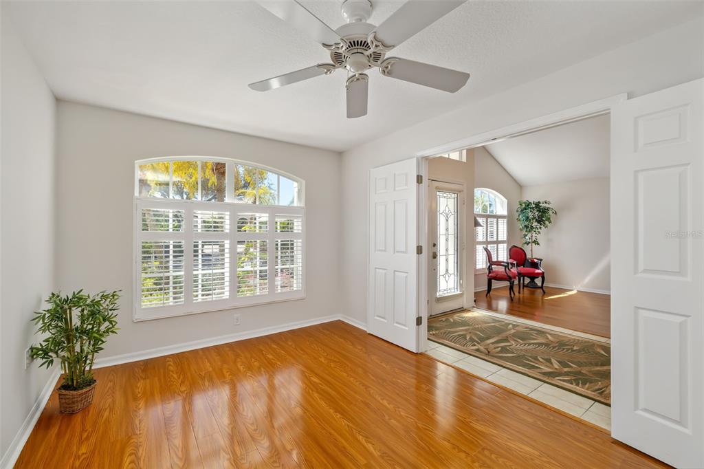 7631 Desert Inn Way Lakewood Ranch, FL 34202 - Photo 24 of 100 a view of a livingroom with wooden floor and a ceiling fan