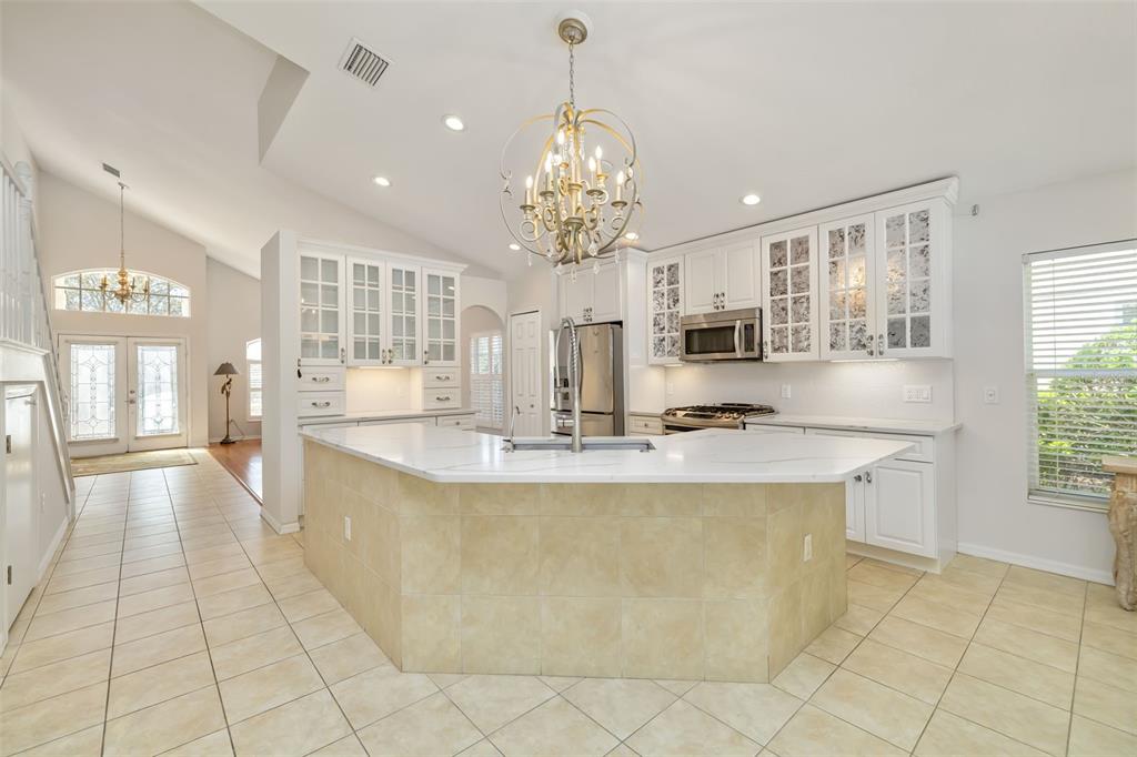 7631 Desert Inn Way Lakewood Ranch, FL 34202 - Photo 29 of 100 a large kitchen with kitchen island granite countertop a large counter top and living room view