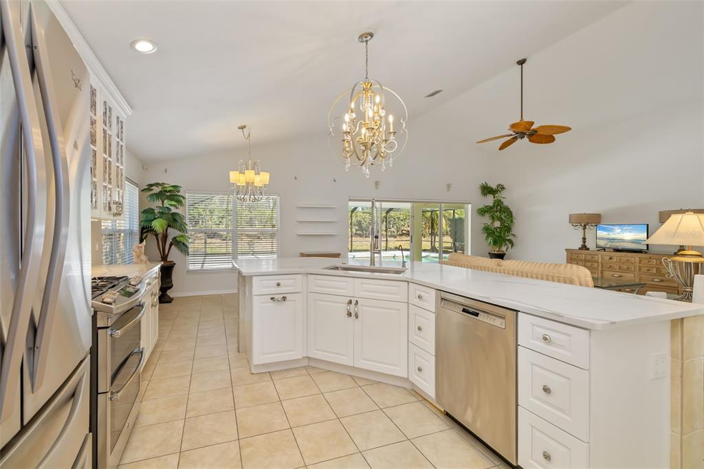 7631 Desert Inn Way Lakewood Ranch, FL 34202 - Photo 31 of 100 a kitchen with white cabinets and chandelier