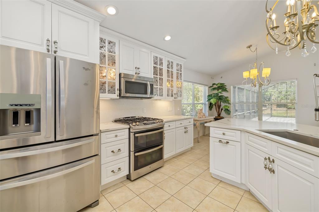 7631 Desert Inn Way Lakewood Ranch, FL 34202 - Photo 32 of 100 a kitchen with stainless steel appliances a refrigerator sink and stove