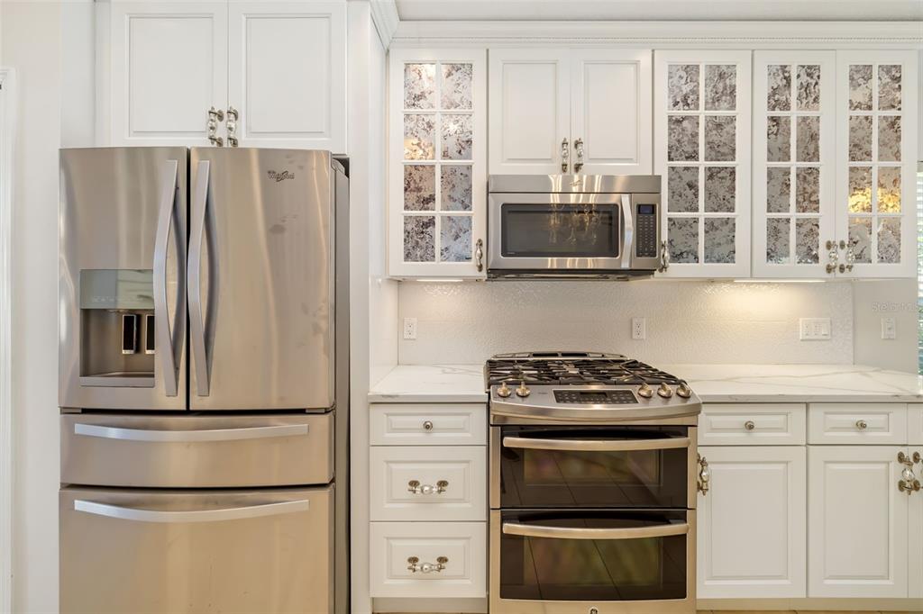 7631 Desert Inn Way Lakewood Ranch, FL 34202 - Photo 33 of 100 a kitchen with stainless steel appliances a stove a microwave and a refrigerator