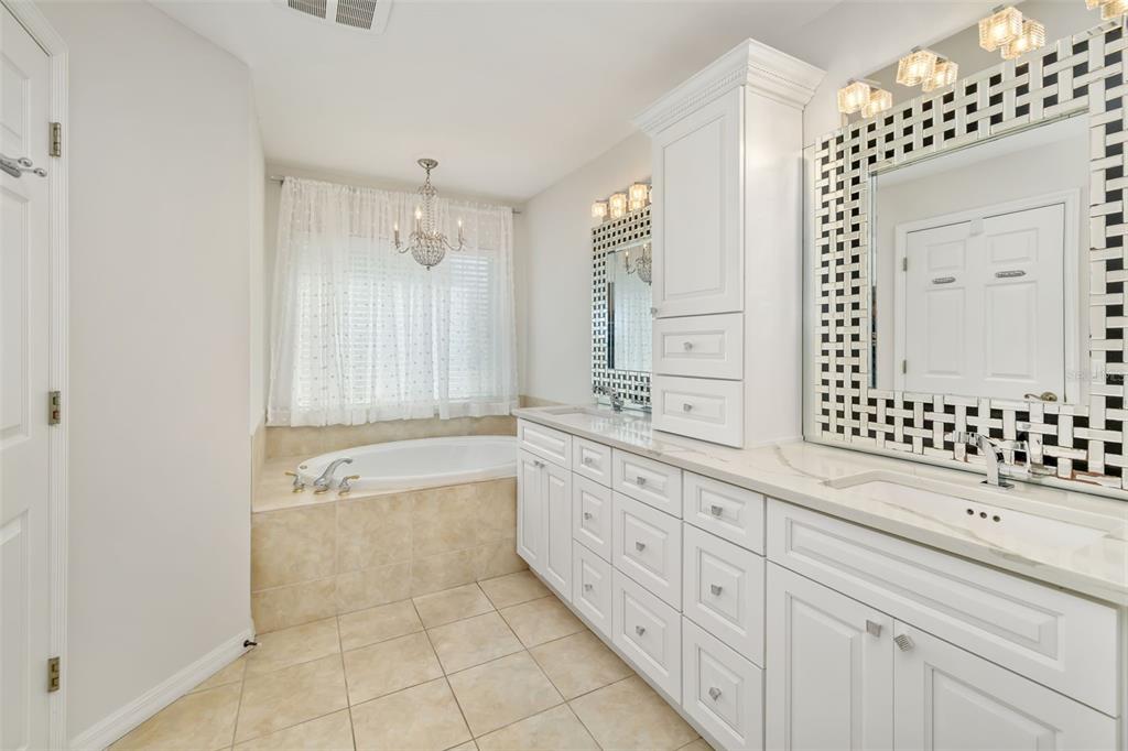 7631 Desert Inn Way Lakewood Ranch, FL 34202 - Photo 42 of 100 a bathroom with a granite countertop sink a mirror a shower and a bathtub